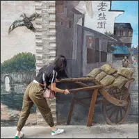 Visitor posing as part of a three-dimensional street mural in Guilin.