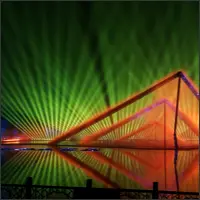 Green laser beams forming a triangular canopy above the water stage.