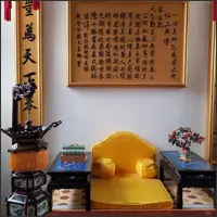 Yellow imperial throne surrounded by traditional Chinese furnishings and calligraph
