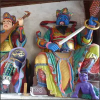 Colorfully painted guardian statues inside Miaozhan Temple in Guandu Ancient Town.