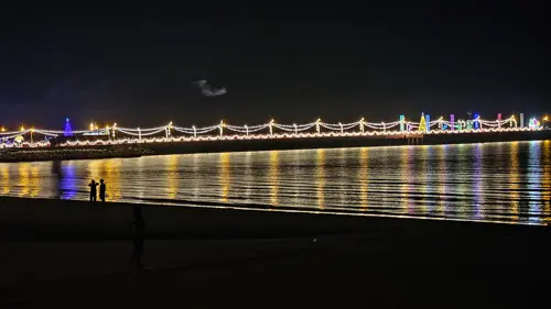 Saranwithi Fishing Pier from the distance with two people on the beach