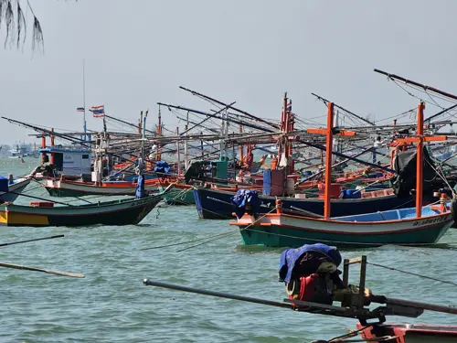 Colorful fishing boats anchored in Prachuap Bay on a windy morning.