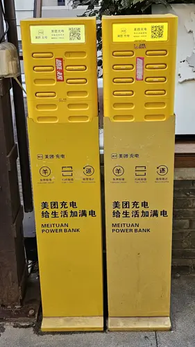 Yellow rental power-bank stations installed along a city street in China.