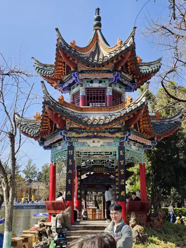 Colorful and intricately decorated pagoda at Green Lake Park in Kunming with ornate roof details and bright painted beams.
