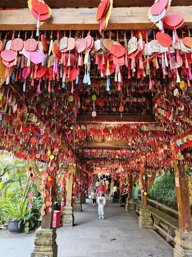 Covered walkway in Manting Park filled with red hanging plaques and ribbons with handwritten wishes