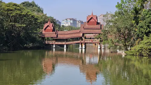 Traditional Dai-style pavilion over a calm lake in Manting Park with reflections in the water