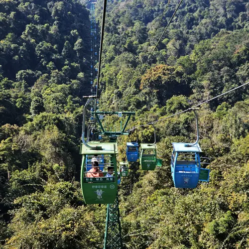 Gondola cable cars traveling above dense forest in Wild Elephant Valley in Xishuangbanna