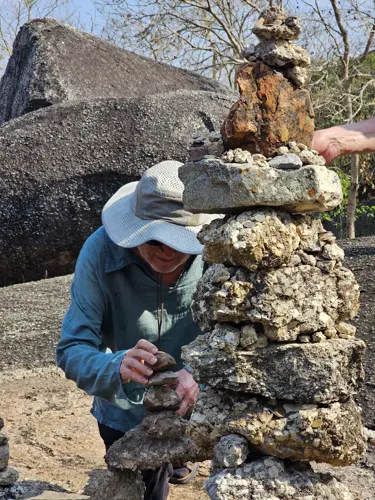 Man reassambling pieces of a cairn that fell down