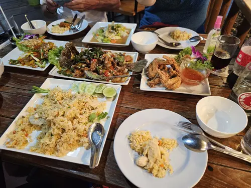 Shared table with multiple Thai dishes at Bay Camp in Prachuap